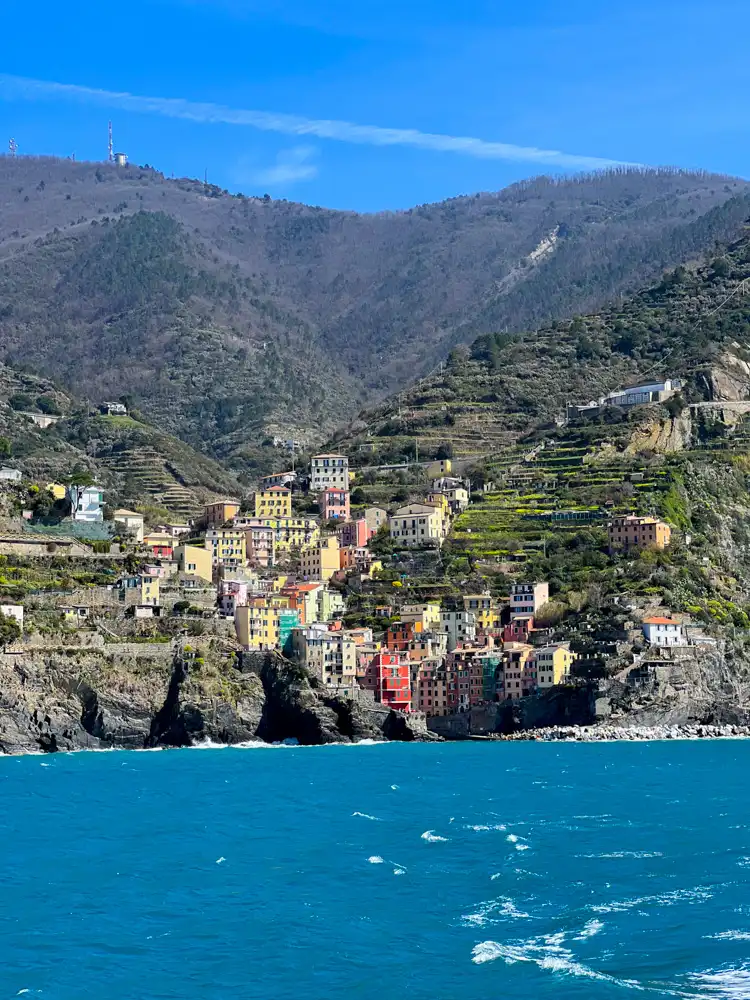 Cinque Terre – vodič za putovanje, iskustva i savjeti 23 Šarene kuće jednog od sela Cinque Terre na strmoj obali, fotografirane s broda